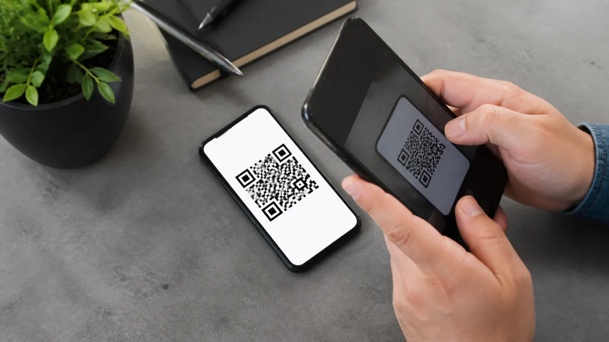 Jedan telefon skenira QR kod prikazan na drugom telefonu